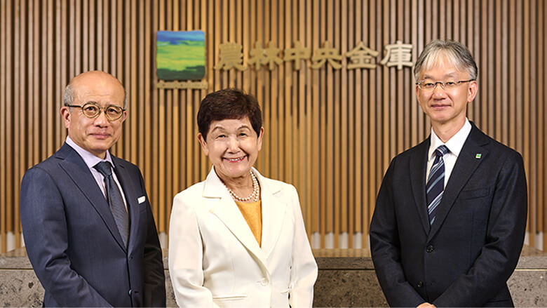 写真：農林中央金庫のロゴが掲げられている壁の前に立っている3名。左から経営管理委員 國廣 正、経営管理委員 坂東 眞理子（2026年6月退任）、常務執行役員 川島 憲治